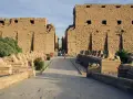 Aleja sfinksów prowadzi do monumentalnych murów świątyni Karnak.