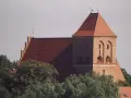 Gotycki kościół w Pucku z cegły, z charakterystycznym dachem i wieżą.