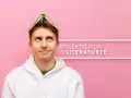 Młody mężczyzna z książką na głowie zastanawia się nad dialektyzacją w literaturze.