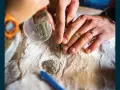 Ręce archeologa i paleontologa delikatnie oczyszczają znalezisko.