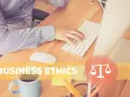 Osoba pracuje przy biurku, klawiatura i myszka. Napis "BUSINESS ETHICS" i symbol wagi. To jest etyka co to.