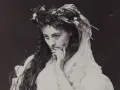 Helena Modrzejewska w wianku z kwiatów, zamyślona. Choć na zdjęciu nie widać dzieci, jej spojrzenie zdaje się tęsknić za nimi.