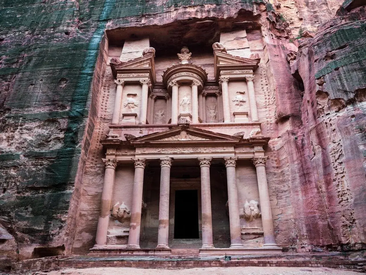 Skalna fasada Al-Chaziny w Petrze w Jordanii, wykuta w różowym piaskowcu. Monumentalna budowla z kolumnami i rzeźbami.