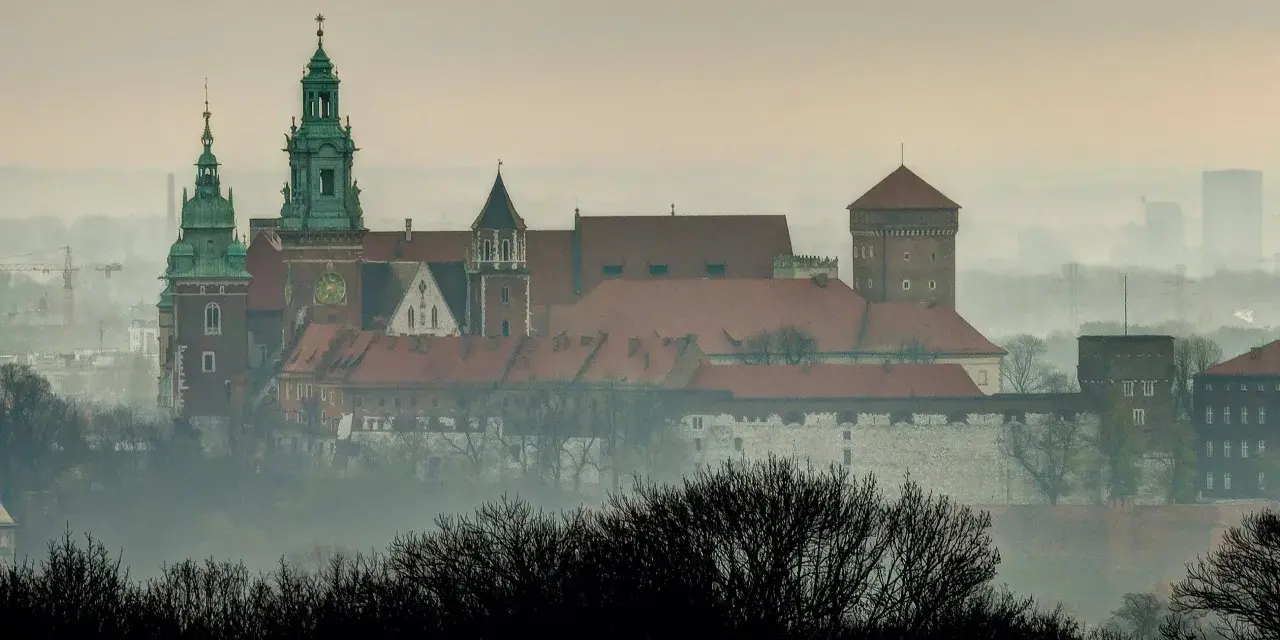 Mglisty poranek nad Wawelem, którego budowę rozpoczęto wieki temu. Zamek królewski wznosi się majestatycznie na wzgórzu.