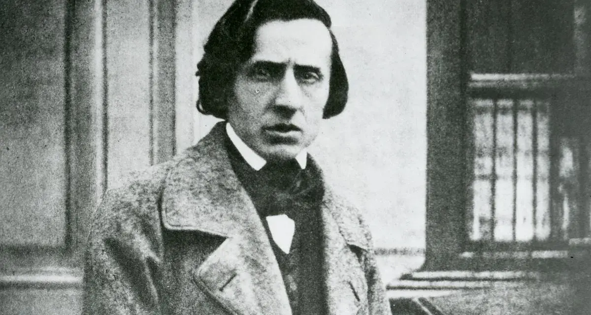 Chopin zdjecie. Fryderyk Chopin, polski kompozytor, w eleganckim płaszczu i z charakterystyczną fryzurą.