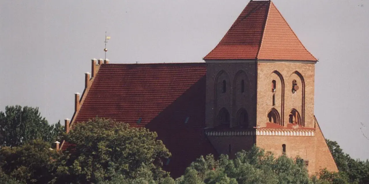 Gotycki kościół w Pucku z cegły, z charakterystycznym dachem i wieżą.