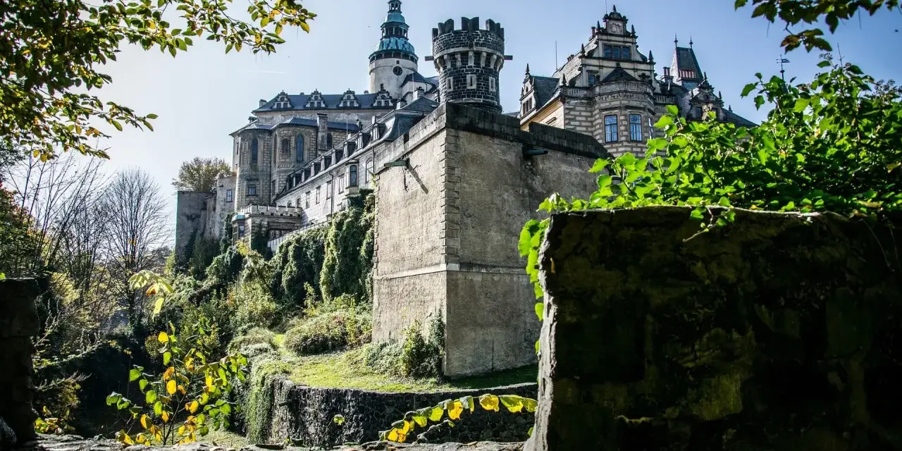 Majestatyczne zamki Czech na wzgórzu, otoczone zielenią i kamiennymi murami, wyglądają jak z bajki.