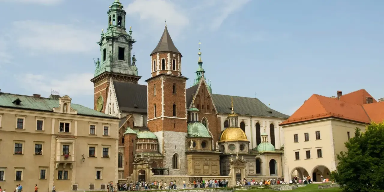 Wawel w średniowieczu – majestatyczna katedra i zamek, świadkowie historii Polski, otoczone zielonym dziedzińcem.