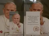 Relikty Jana Pawła II. Na zdjęciu papież w białej szacie, z krzyżem na szyi. Obok cytat z jego testamentu.