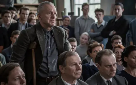 Mężczyzna z laską przemawia do grupy ludzi. Scena z filmów o artystach, gdzie dyskusja o sztuce jest równie ważna jak samo tworzenie.