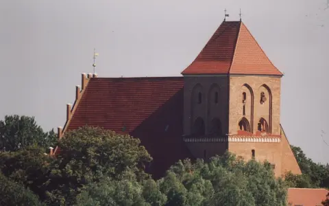 Gotycki kościół w Pucku z cegły, z charakterystycznym dachem i wieżą.