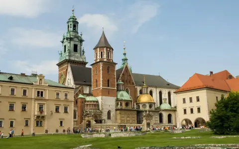 Wawel w średniowieczu – majestatyczna katedra i zamek, świadkowie historii Polski, otoczone zielonym dziedzińcem.