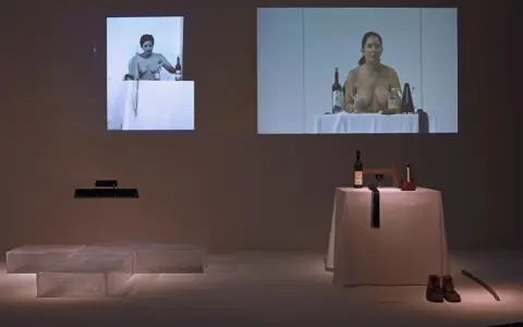 Fragmenty performance'u Mariny Abramović: kobiety przy stołach z winem i przedmiotami, obok instalacja z lodu.