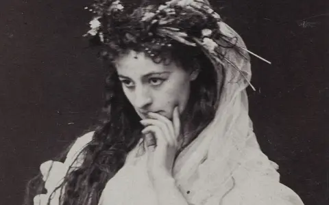 Helena Modrzejewska w wianku z kwiatów, zamyślona. Choć na zdjęciu nie widać dzieci, jej spojrzenie zdaje się tęsknić za nimi.