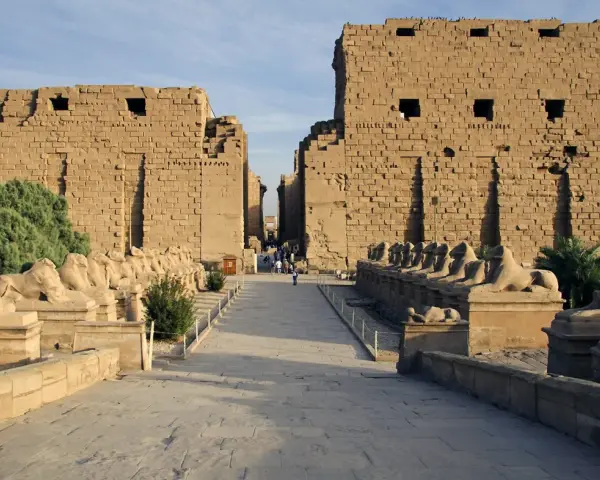 Aleja sfinksów prowadzi do monumentalnych murów świątyni Karnak.