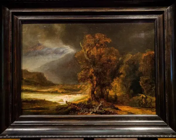 Krajobraz z burzą i rzeką, jeden z **rembrandt najpopularniejsze obrazy**. Mroczne niebo, drzewa i postacie w oddali.