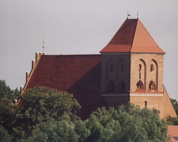 Gotycki kościół w Pucku z cegły, z charakterystycznym dachem i wieżą.