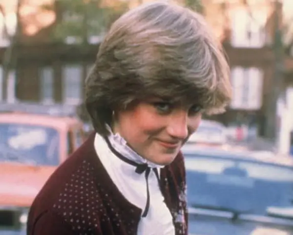 Młoda Diana Spencer, zanim została księżną, w bordowym sweterku i białej bluzce. Jej arystokratyczne pochodzenie widać w subtelnych gestach.