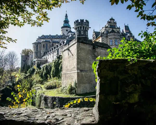 Majestatyczne zamki Czech na wzgórzu, otoczone zielenią i kamiennymi murami, wyglądają jak z bajki.