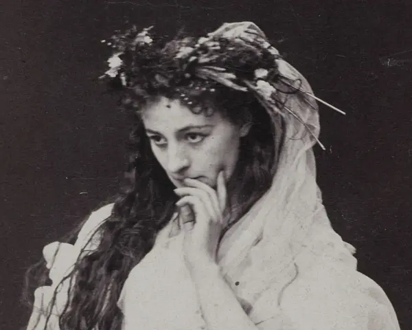 Helena Modrzejewska w wianku z kwiatów, zamyślona. Choć na zdjęciu nie widać dzieci, jej spojrzenie zdaje się tęsknić za nimi.