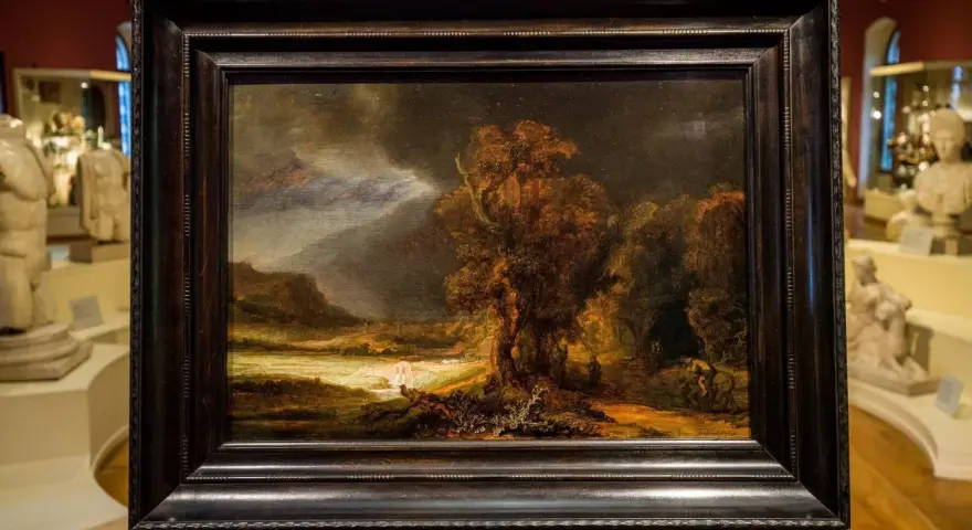 Krajobraz z burzą i rzeką, jeden z **rembrandt najpopularniejsze obrazy**. Mroczne niebo, drzewa i postacie w oddali.