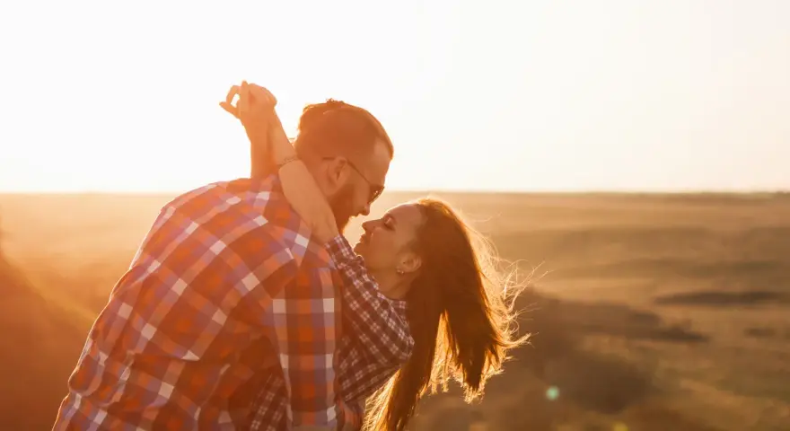 Para kochająca się w zachodzącym słońcu, uosobienie erosa i filii.
