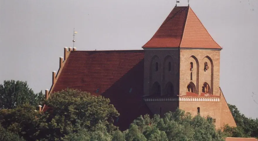 Gotycki kościół w Pucku z cegły, z charakterystycznym dachem i wieżą.