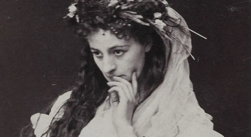 Helena Modrzejewska w wianku z kwiatów, zamyślona. Choć na zdjęciu nie widać dzieci, jej spojrzenie zdaje się tęsknić za nimi.