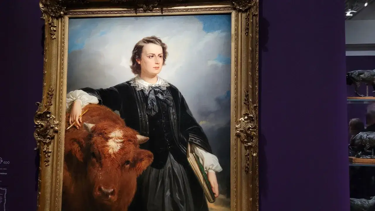 Portret artystki Rosa Bonheur z bykiem, trzymająca pędzel i szkicownik.