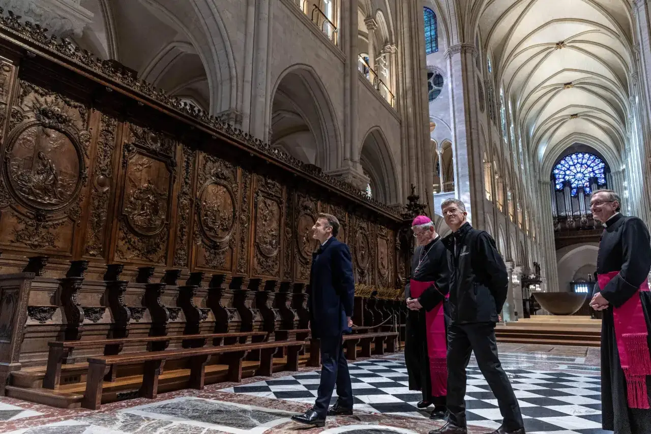 Emmanuel Macron i duchowni zwiedzają wnętrze katedry Notre Dame, kt&oacute;ra po pożarze jest w trakcie odbudowy.