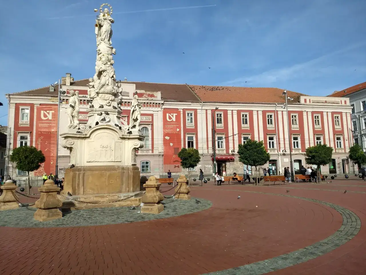 Kolumna Tr&oacute;jcy Świętej i zabytkowe budynki w Timișoara, tworzące piękne atrakcje miasta.