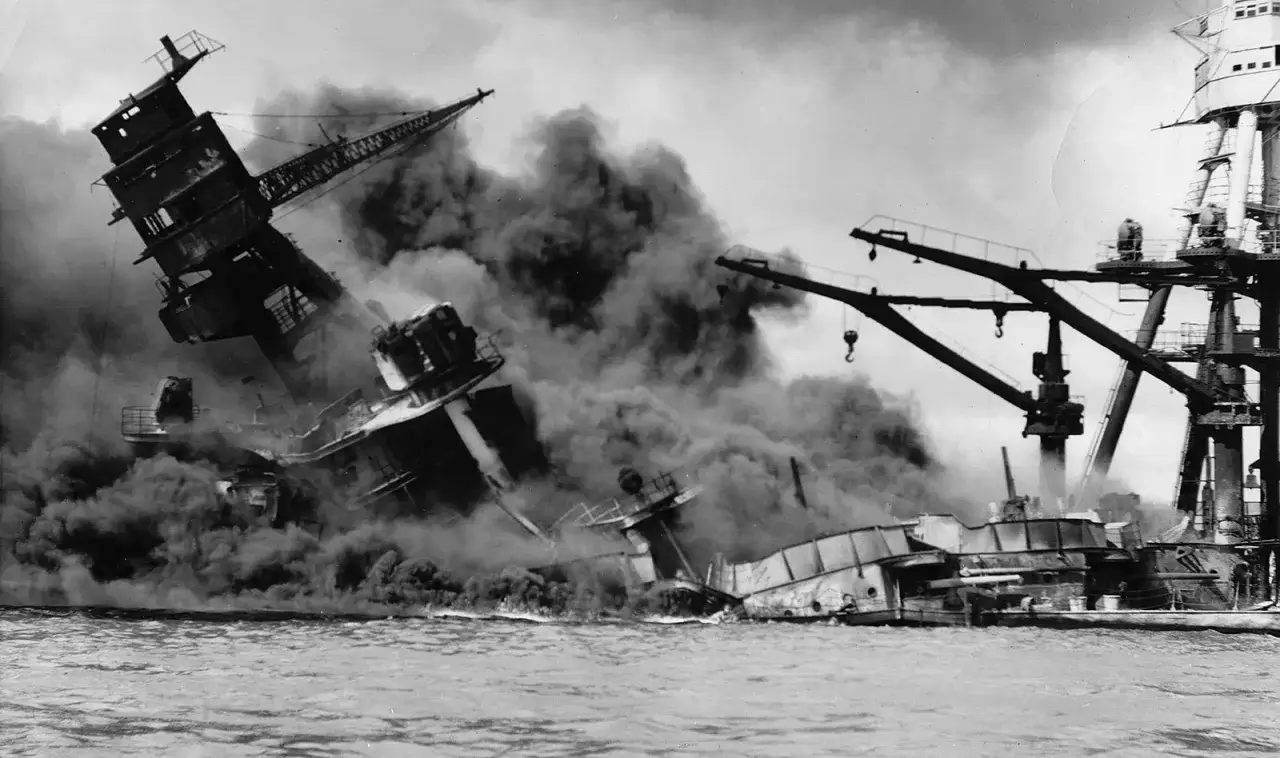 Dym i zniszczenie po ataku na Pearl Harbor. Okręty toną, a pożary trawią bazę.