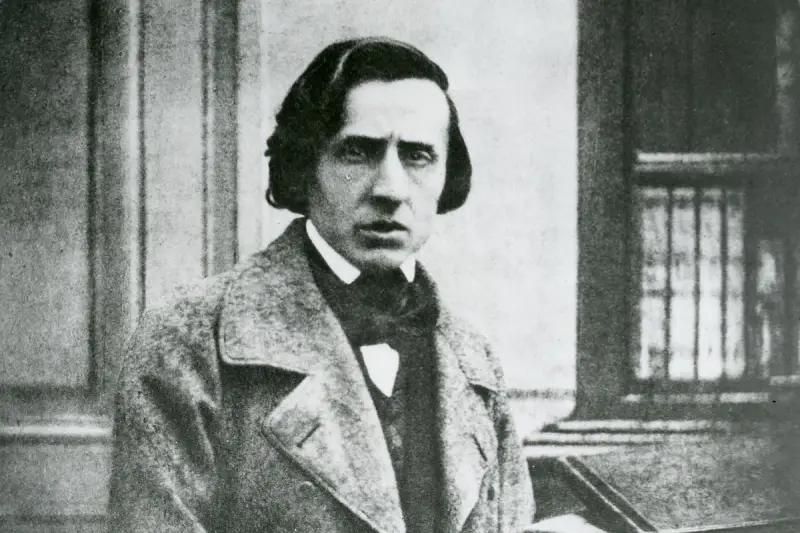 Chopin zdjecie. Fryderyk Chopin, polski kompozytor, w eleganckim płaszczu i z charakterystyczną fryzurą.